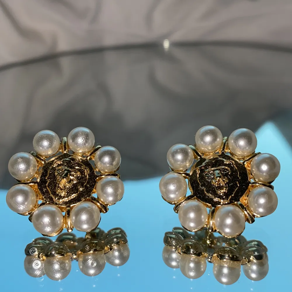 50-tals inspirerande örhängen med pärlor och ett motiv av lejon. Accessoarer.