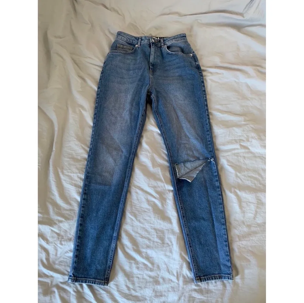 Mom jeans med hög midja och hål vid knät. Använda en gång så i princip nya! Storlek 36. Stretchiga och standard benlängd . Jeans & Byxor.