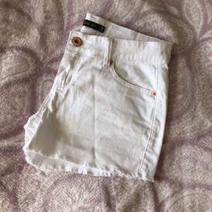 Vita korta shorts med små fransar nedtill. Aldrig använda!