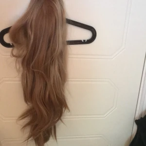 Blond lång peruk med slingor - Säljer denna blonda peruk då jag inte använder den.  Den är lång och har slingor. Hårnät medföljer inte. Inte lace front men kan matchas ihop med en mössa eller hatt om man vill! 200kr+frakt