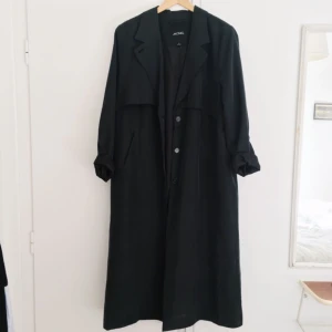  - Jättefin kappa i tunt material från Monki . Gråblå i färgen och perfekt till våren! Originalpris 700. Finns ett skärp att ha i midjan men ena öglan har gått av så litet hål i midjan. Men går lätt att laga. Köparen står för frakt!