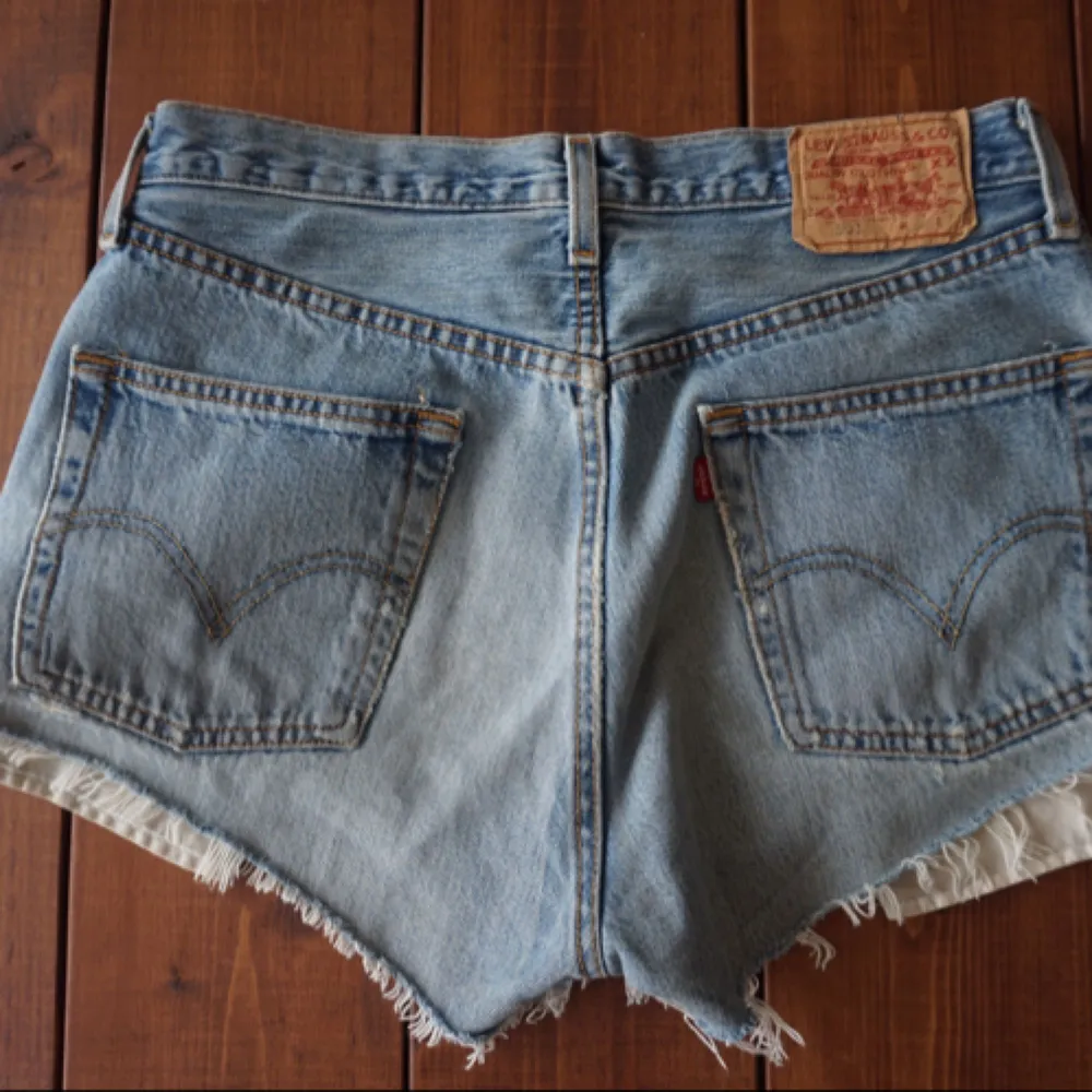 Levi's vintage jeansshorts i klassiska modellen 501 i tumstorlek 32. Snygg ljusblå färg med snygga slitningar. Skulle gissa att de passar bra till dig som är storlek M i vanliga fall. Det går utmärk att betala med Swish och köparen står för fraktkostnaden. . Shorts.