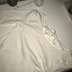 - Trekvartslång ärrad topp från Gina Tricot. Har en fin detalj i ryggen då den är öppen med en rosett. Aldrig använd. Köpare står för frakt.