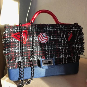  - Axelbandsväska med motiv i tyg och läderimitation. Kedja och andra detaljer i gråfärgad metall. Sparsamt använd, få spår av användning.