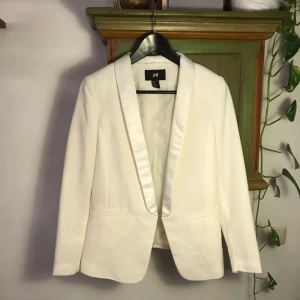  -  Vit öppen kavaj i fint skick! Knappt använd. Storlek 38 men skulle säga att den även passar 36. Fraktar endast, ej medräknat i priset.