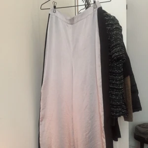  - vida, vadlånga byxor i silkigt material. ljusgrå med svarta ränder på sidan. aldrig använda! de flesta priser kan diskuteras, skriv i PM med bud!  jag möts upp i Stockholm eller skickar mot fraktkostnad.