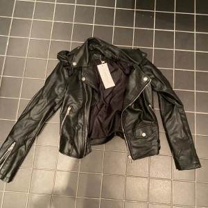 Skinnjacka - En oanvänd skinnjacka med prislappen kvar. Säljs för 200kr i storlek s. Jackan är ifrån chiquelle