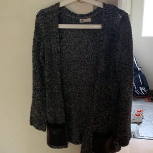 HM strl 146/152 - Grå/ svart Kofta från H&M med läderfickor. För barn 11-12, men passar STRL XS/ S. Bra skick, använd flera gånger. Köpt för c.300