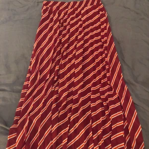 Randig plisserad kjol strl S - Plisserad kjol från Ichi. Rosa med röda och vita ränder. Ganska stor i storleken. Gratis frakt.