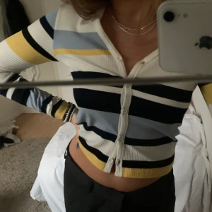 Randig Kofta - Jättesöt  kofta med ljusblå, marinblå, svarta, vita och gula ränder i storlek S💕 Kan mötas eller frakta!