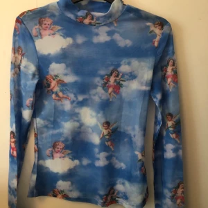 Meshtröja änglar - Säljer min fina meshtröja med änglar!!!! Jag har aldrig använt den eftersom att den inte var min stil, jag har mest svarta kläder på mig men tycker fortfarande den är super snygg! 60 kronor inklusive frakt och om flera är intresserade, buda! Storlek XS/S