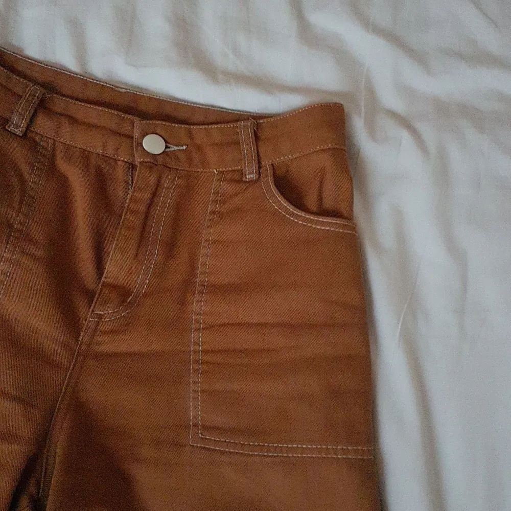 Ett par skitsnygga bruna byxor från monki. Som är vida med en cool synlig sömn längs benet, längst ner på byxan och runt fickorna. Säljer för att de inte passar min stil längre. Frakt tillkommer.. Jeans & Byxor.