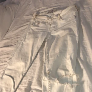 Vita jeans med hål - Vita jeans med hål i ena knät från hollister
