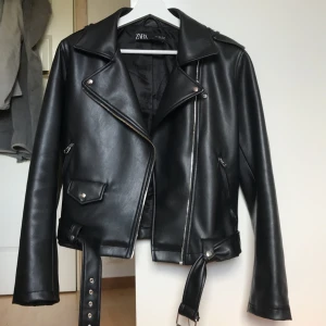 Skinnjacka från Zara - Skinnjacka i fakeläder från Zara, inköpt i Paris för 500kr. Inga defekter på varken ”skinnet” eller metallen, förutom en liten skrapa på vänster arm (se bild 2). Annars som ny!! Storlek L, men passar xs-l beroende på hur man vill att den ska sitta.