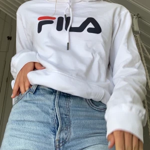 Fila hoodie - Vit hoodie från fila, köpt i killavdelningen på sportshopen, därav lite stor i storleken, för 699kr men aldrig kommit till användning. Köparen står för frakten.