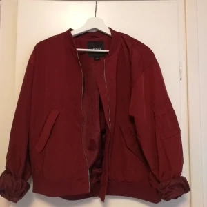 Bombarjacka, röd - Röd bombarjacka. Perfekt för våren sommarn och öven tidig höst. Använd några få gånger. Frakt tillkommer. 