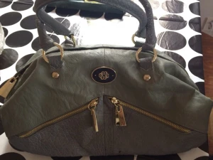  - Grå Skinnväska med guld detaljer från märket Micha.
Köpt flera år sedan men aldrig använt.
Innerfick och mobilfack. Snygg lila innerfoder.
Frakt tillkommer. 