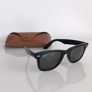 Ray-Ban Wayfarer RB2140 - Klassiska Wayfarers i svart köpta på Åhléns 2018 och sparsamt använda. Självklart äkta! Några små märken bakom ena örat (se bild 3) men inget som syns och i övrigt väldigt fint skick. Fodral medföljer. Nypris 1600kr