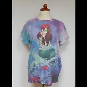 T-shirt med tatuerad Ariel. Jätte skön och lite annorlunda tröja som är använd några gånger men fortfarande i original kvalitet. Den har en ganska rak form💜💙💚