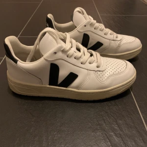 Skor från Veja - Ett par nästintill oanvända vita sneakers med svarta detaljer från Veja! Nypris 1350kr. Möts helst upp för att undvika dyra fraktkostnader. Annars står köparen för frakten! 