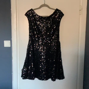 Svart paljettklänning  - Svart paljettklänning från Nelly i storlek L, fin till nyår! Använd 1 gång