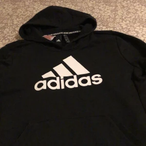 Svart adidas hoodie  - Säljer nu min väldigt sköna svarta adidas hoodie som jag tyvärr har vuxit ut. Finns inga fel på tröjan så den är i väldigt bra skick😊 skriv privat till mig för intresse.