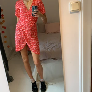 ”Vila” wrap dress - En vitblommig röd wrap dress från Vila köpt för 3 år sen, fortfarande bra skick!🌞 Säljer pga inte min stil längre men underbar för sommaren!  