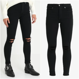 Svarta jeans slitage knäna 32/XS - Färg: svarta.  Strl: 32.  Mått: (Yttermått)Från midja till benslut: 91cm.  (Innerbensmått)Från grenen till benslut: 71cm.  Midjemått framifrån: 32,5cm.  Jeans från H&M, tighta hela vägen. Slitage på knänen. Fickor fram & bak. OBS. Helt nya, fint skick!