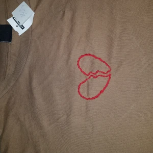 T-shirt med broderat hjärta - En tröja köpt secondhand (men kommer ursprungligen från Gina Tricot) i storlek M. Jag har själv broderat hjärtat. 