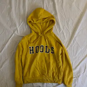 Gul hoodie med texten HOODS på framsidan. Hoodien är knappt använd och kommer från Gina Tricot. Storleken är en stor S. 