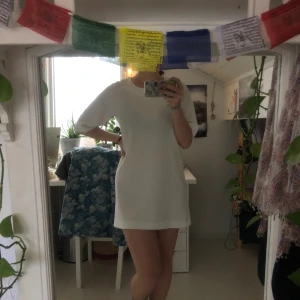 Enkel clean cut vit klänning - En vit klänning från Monki i storlek 38. Har ett texturerat tyg som faller rakt. Perfekt som studentklänning! Den har en kort dragkedja i ryggen. Är i fint skick!
