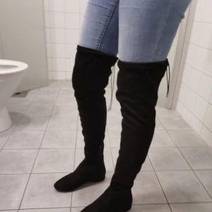 Knähöga stövlar  - Storlek 37. Finns snöre att knyta där bak.  