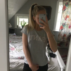 Grå Gant t-shirt  - Skön grå gant tröja. Två små hål längre ner på tröjan. Kolla tredje bilden. Syns knappt.