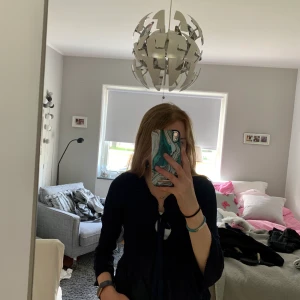 Marinblå blus  - Säljer en marinblå blus, har volangarmar som är 3 kvartslånga. Fin knytning upptill. 