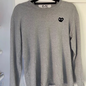 Comme des garcons tröja - En snygg grå tröja från comme des garcons som är inköpt för två år sen. Har tyvärr inget kvitto men är köpt på NK. Den har ett litet hål på högre ärmen men som knappt syns. Förrut det så är den i begagnat skick och är i storlek L men sitter som M. 