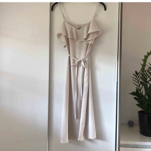 Fin midi-klänning - Midiklänning i en ljus-beige färg. Kan dras ihop i midjan med ett band, se bild nr 1. Går att bäras utan bandet också då det inte finns några loops som håller fast det (Frakt ingår i priset) 