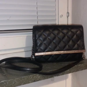 Väska - Svart axelbands väska från glitter. Använt denna väskan innan men den har inga skador eller fläckar som man ser på bilderna.