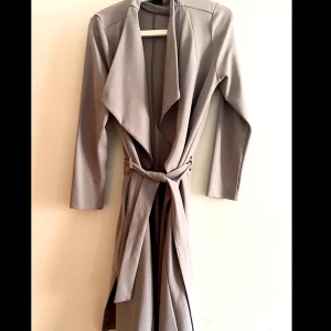 Grå beige kappa  - Fin gråbeige kappa från Newlook bra skick! Köpt från Nelly 