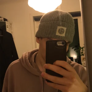 Stone island mössa grå - Grå Mössa från stone island, äkta som du ser. Använd hyfsat mycket och det syns på vita märket lite, tror den kostade 700 ny, köpt i stone island butik i sthlm, väldigt varm