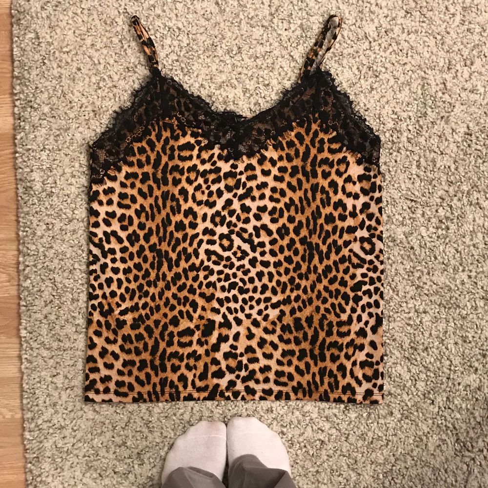 Tunt leopardmönstrat linne med svart spets upptill. Köpt i storlek XL för att den ska hänga slappt över kroppen (jag är XS-M beroende på). Justerbara axelband och i gott skick . Toppar.