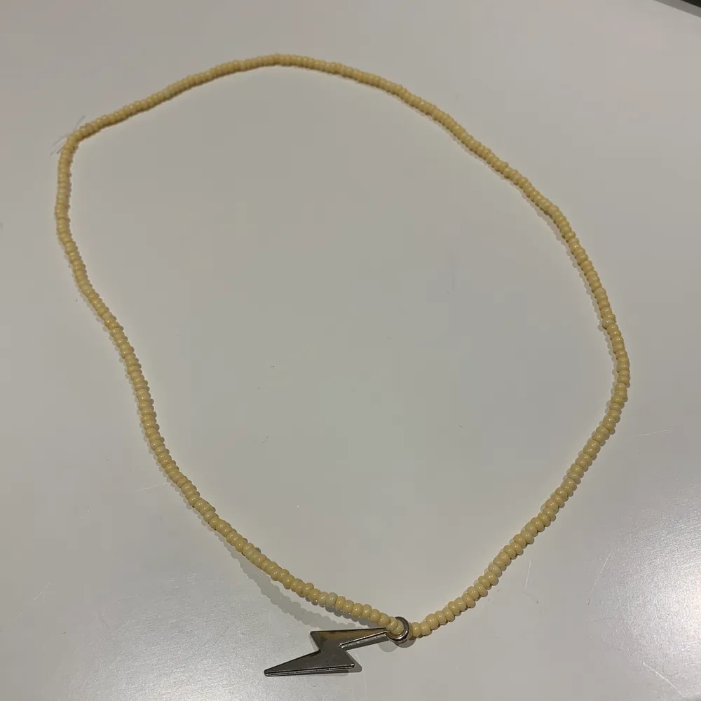här är ett halsband med en metall-blixt med gula fina pärlor 💫. Accessoarer.