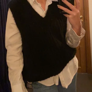 Svart stickad väst  - Svart V-ringad stickad väst. Super snygg utan något under men även med antigen T-shirt eller skjorta. XS/S. Vid snabbt köp 300kr inklusive frakt! 