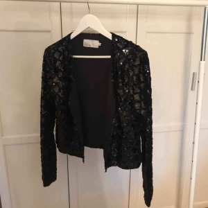  - Köpt på Nelly Glittrig tröja, man får lite känslan av att de är en blandning mellan en kavaj och en kofta. Paljetter på. Aldrig använd, endast provad. Älskar den egentligen, men hittar inget bra tillfälle att ha den därför säljer jag den. 