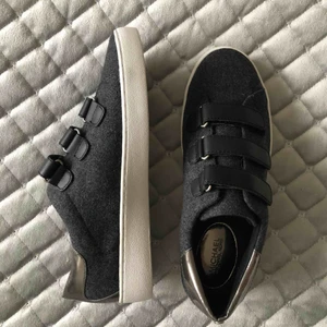  - Ett par sneakers från Michael Kors med silverdetalj bak på hälen, vit sula och mörkgråa i färgen. Aldrig använda!! Originallåda finns och medföljer. 