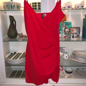 Röd, tight klänning från H&M med spaghetti straps och rysch på sidan. 