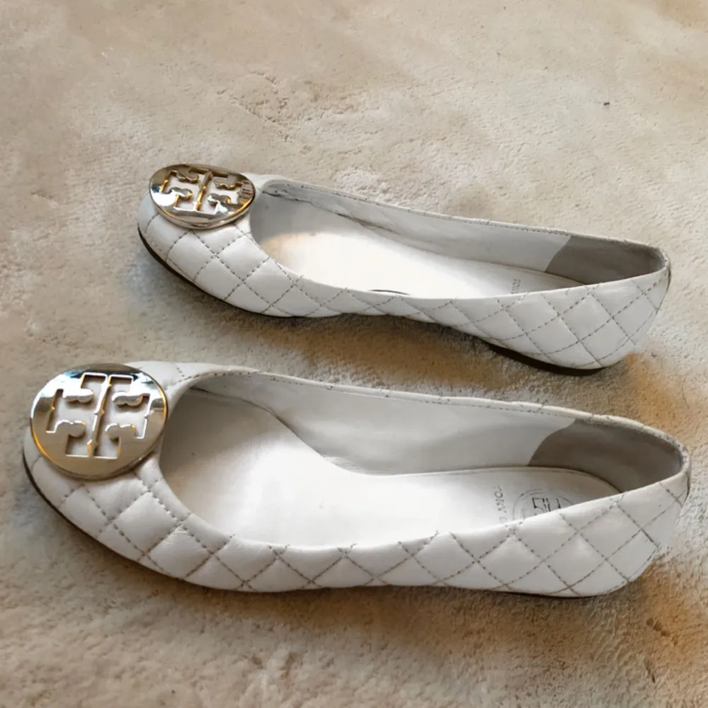 Äkta ballerinaskor från Tory Burch Använd ett fåtal gånger - superbra skick Vita skor med guldlogga Köparen står för eventuell frakt på 80kr. Skor.