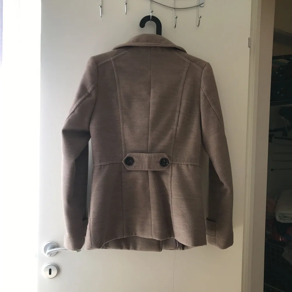 Stilig vardaglig kappa i beige/brun färg, sitter väldigt fint och tajt vid midjan. Använd knappt 3-4 gånger. Köpt från H&M för 499 kr, Nytt pris: 120 kr. . Jackor.