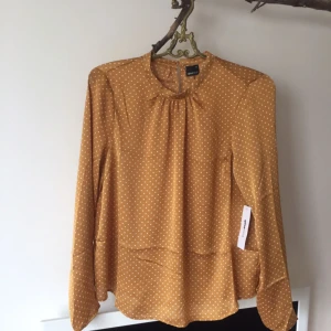  - Oanvänd blus från gina med tag kvar. Vacker "senapsgul" med små vita prickar i silkesblandning. Stl 40 men passar även 38a.    Garderobsrensing, se mina andra annonser. Möjlighet att samfrakta.   Köparen betalar frakt.  Ansvarar ej för postens ev slarv. 