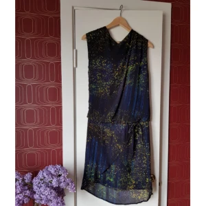  - Klänning från Samsoe & Samsoe. I flera lager skirt tyg med drop waist som ger lite 20-talskänsla. Lätt asymmetrisk över axlarna. Vackert print.  Inga fel, perfekt skick. Sparsamt använd. 