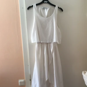  - Vit sommarklänning öppen i ryggen och i benet fram.